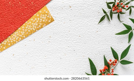 A festive and elegant flat lay composition featuring traditional Japanese elements. The background consists of textured white washi paper adorned with gold and silver flakes, providing ample copy space. In the upper left and lower left corners, a branch of Nandina domestica (heavenly bamboo) with vibrant red berries and deep green leaves adds a natural touch. On the right side, two diagonally layered pieces of patterned paper are visible: a rich red textured paper with subtle gold accents, and a yellow paper featuring a delicate gold checkered pattern overlaid with white and pink cherry blossom flowers. This image evokes a sense of Japanese tradition, celebration, and natural beauty, ideal for New Year greetings, cultural events, or decorative projects.
