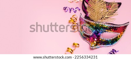 Festive face mask for carnival or masquerade celebration on colored banner background. Copy space