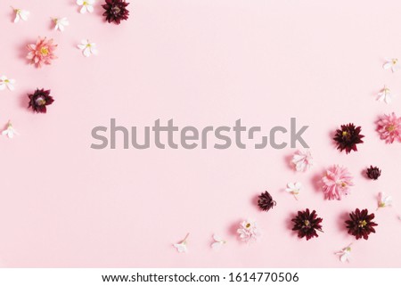 Festive flowers composition. Frame made of pink and purple small flowers on pink background.