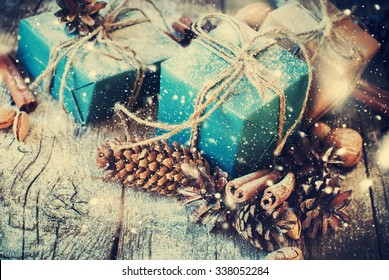 Festive Gifts Decorated with Linen Cord, Cinnamon, Pine cones, Walnuts. Toned image. Snow Drawn