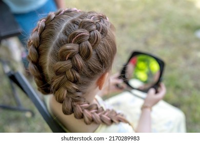 Festive hairstyle from braid on a child girl with long hair, back view. - Shutterstock ID 2170289983