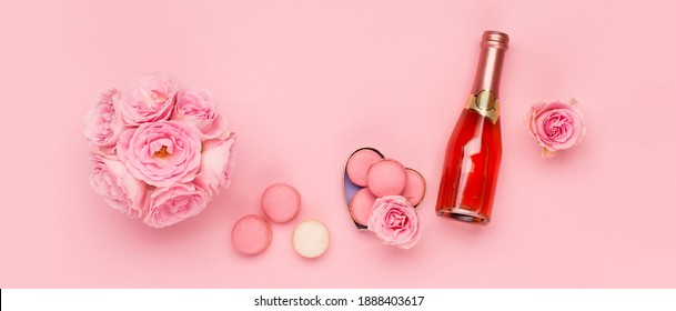 Festive Holiday Greeting Card For Valentines, Birthday, Woman Or Mothers Day. Flowers, Bottle Of Wine, Sweets On Pink Background. Valentines Day Concept. Flat Lay, Top View, Copy Space.