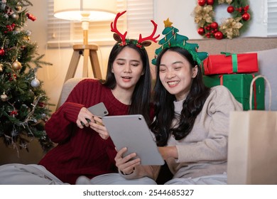 Festive Lesbian Couple Enjoying Holiday Season Together with Digital Tablet and Christmas Decorations - Powered by Shutterstock