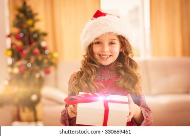 Festive little girl opening a gift at home in the living room