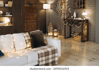 Festive living room setup with cozy sofa wrapped in string lights, plaid blanket, and cushions. Background includes a decorated console table, lanterns, and floor lamp - Powered by Shutterstock