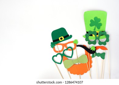 Festive Masks For A St. Patrick's Day On A White Background. Fancy Dress. Party Concept. Flat Lay Objects With Paper Craft On White Wallpaper At Home Office Desk With Copy Space.