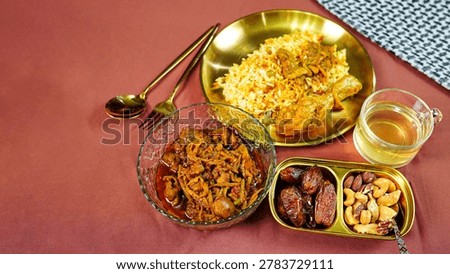 Festive Middle Eastern dinner table with chicken biryani, spicy curry, dates and traditional halal side dishes. Warm hospitality and Ramadan celebration food concept.