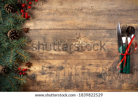 festive New Year Christmas dinner concept. Christmas decorations and Cutlery on a dark rustic table. Christmas table place setting. Winter holidays background. Top view, flat lay, copy space