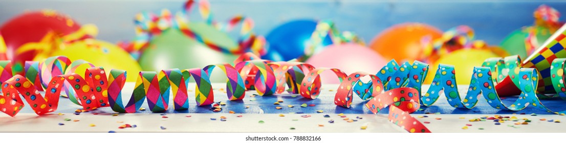 Festive panorama party or carnival banner or header with colorful balloons, confetti and coiled streamers
