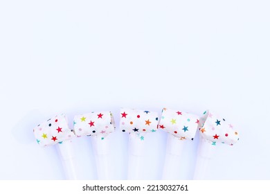 Festive Pipes And Horns On A White Background. Congratulatory Background For Your Text. Background For A Postcard Or Banner For A Birthday, New Year Or Other Holiday. Noise Makers