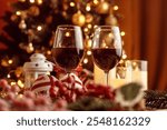 Festive red wine glass surrounded by Christmas decorations, creating a cozy holiday vibe. Perfect for Christmas, holiday season, festive celebrations, winter drinks, seasonal parties and holiday cheer