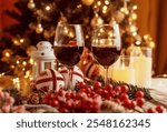 Festive red wine glass surrounded by Christmas decorations, creating a cozy holiday vibe. Perfect for Christmas, holiday season, festive celebrations, winter drinks, seasonal parties and holiday cheer