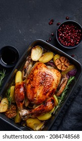 Festive roasted chicken in pomegranate sauce with potatoes in a gray ceramic mold. Dark background. Thanksgiving Day. Top view. Copy space - Shutterstock ID 2084748568