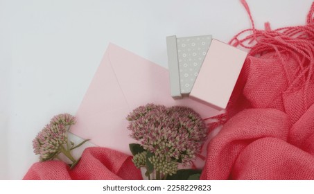 Festive, romantic concept. Pink postal envelope, flower,
 gift box and pink scarf, stole on a pastel, white background. Copy space, space for text, postcard, background, - Shutterstock ID 2258229823