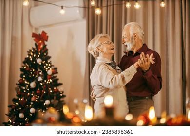 A festive senior couple is celebrating christmas and new year's eve at home while dancing. - Powered by Shutterstock