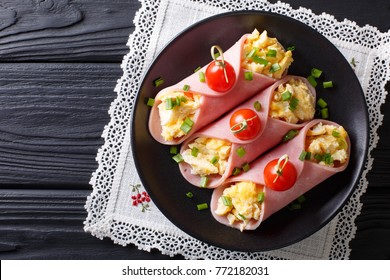 Festive Snack: Roll Ham Stuffed With Scrambled Eggs And Tomatoes Close-up On A Plate. Horizontal Top View From Above
