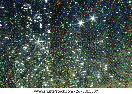 Festive sparkling background with silver sequins reflecting multicolored light. Bright shimmering texture, festive and vibrant atmosphere.