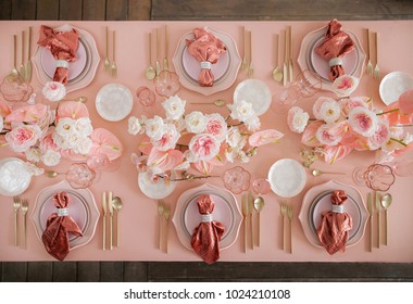 Festive table decor. In pastel pink colors with golden cutlery. With different natural colors roses, peonies, anthurium. Luxury wedding, party, birthday. View from above - Powered by Shutterstock