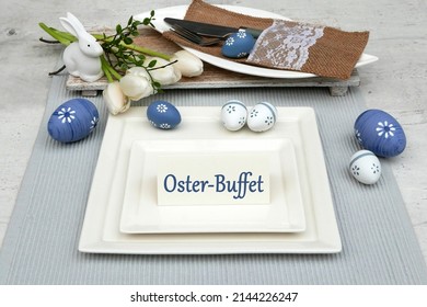 Festive Table Decoration For Easter. Plates, Cutlery, Napkins And Easter Decorations With The Text Oster Buffet On A Card. Oster Buffet Means Easter Buffet.