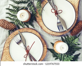 Festive Table Setting Among Winter Decorations And White Candles. Top View, Flat Lay. The Concept Of A Christmas Or Thanksgiving Family Dinner.