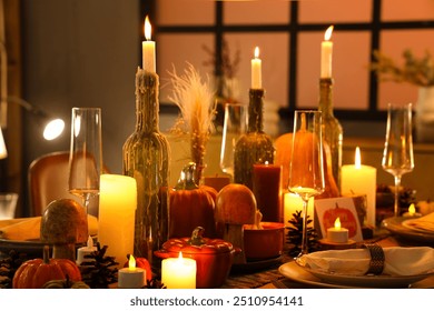 Festive table setting with burning candles, pumpkins and greeting cards for Thanksgiving Day at evening - Powered by Shutterstock