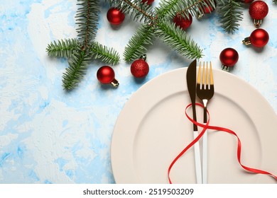 Festive table setting with cutlery, red ribbon, fir tree branches and Christmas balls on blue background - Powered by Shutterstock