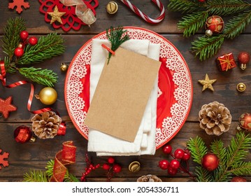 Festive table setting with ornaments, fir tree branches and blank card top view. Mockup of Christmas or New Year invitation card on dark wooden table flat lay, copy space - Powered by Shutterstock