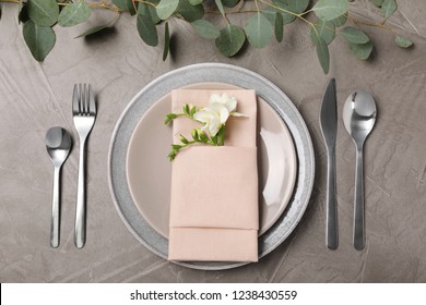 Festive table setting with plates, cutlery and napkin on grey background, flat lay