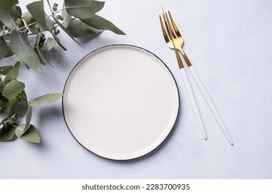 Festive table setting for a spring celebration, wedding, birthday or mother's day with eucalyptus branches on a light background. The concept of the restaurant menu. Top view and place to copy. - Powered by Shutterstock