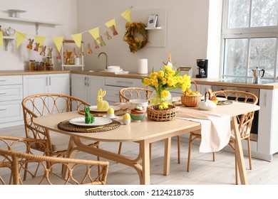 Festive table setting with yellow tulips and Easter rabbits in kitchen