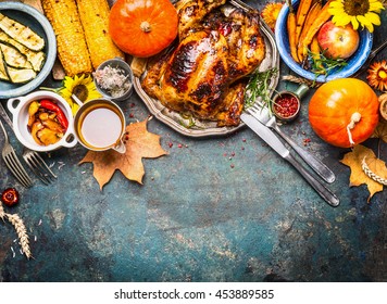 Festive  Thanksgiving Day Food Background With Roasted Whole Turkey Or Chicken And Sauce, Harvest Vegetables: Corn, Pumpkin,carrots With Cutlery On Dark Rustic Kitchen Table, Top View, Border