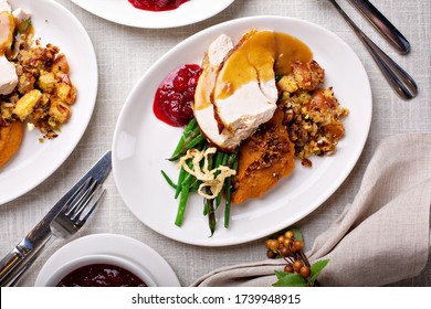 Festive Thanksgiving Dinner Table With Plates Of Food, Turkey And All The Sides