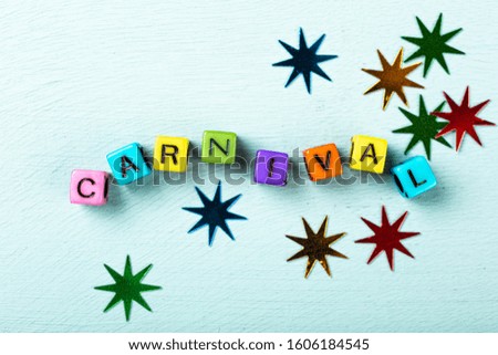 Festive turquoise background with colorful cubes with text Carnival. Greeting card concept voor carnival and party. Copy space, top view, flat lay. Banner