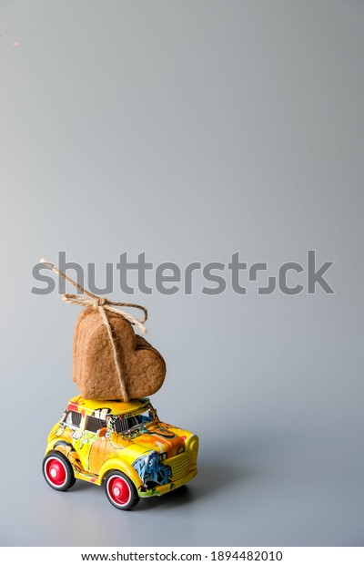 festive valentine's day
holiday flat lay. annual holiday shopping concept and 
reasonable
consumption.Cookies form of heatrs tied jute rope on a yellow car
on grey
background.04.01.2021-tivat