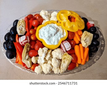 Festive vegetable platter with colorful peppers, cucumbers, radishes, carrots, cherry tomatoes, and creamy dips in bell pepper bowls. Perfect for Thanksgiving, Christmas, or holiday celebrations. - Powered by Shutterstock