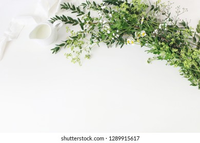 Festive Wedding, Birthday Table Scene With Eucalyptus Parvifolia, Silk Ribbon, Wild Meadow Flowers And Milk Pitcher On White Table Background. Rustic Feminine Design. Flat Lay, Top View. Empty Space.