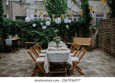 Festive wedding table setting with flowers at small reception in backyard in summer. - Powered by Shutterstock