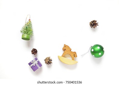 Festive White Background. Christmas Tree, Pine Cones, Purple Gift Box, Toy Wooden Horse And Green Ball. Flat Lay New Year Photo. Xmas Design. Mock-up, Free Space For Text