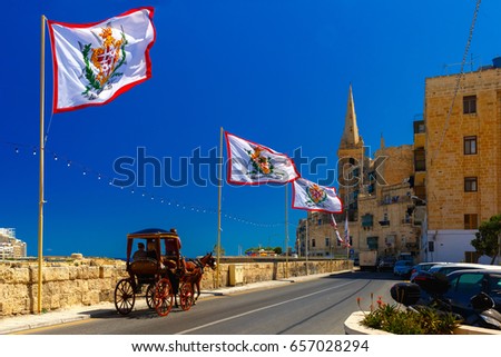 Festively decorated street with flags of all the Grand Masters of the Sovereign Military Order of Malta in the old town of Valletta, Malta