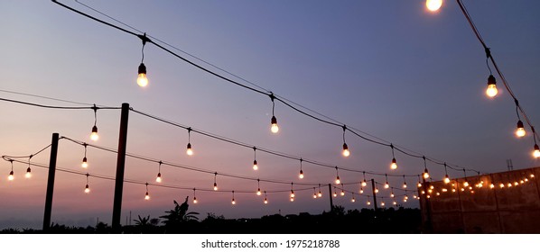 Festoon string lights outdoor at sunset - Powered by Shutterstock