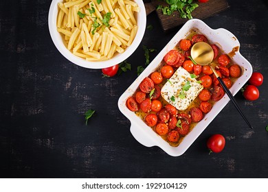 Fetapasta. Trending viral Feta bake pasta recipe made of cherry tomatoes, feta cheese, garlic and herbs in a casserole dish. Top view, above, copy space.