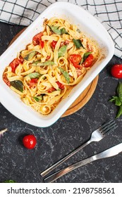 Fetapasta. Trending Viral Feta Bake Pasta Recipe Made Of Cherry Tomatoes, Feta Cheese, Garlic And Herbs In A Casserole Dish. Top View