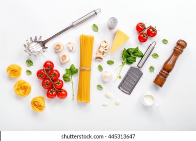 Fettuccine And Spaghetti With Ingredients For Cooking Pasta On A White Background, Top View. Flat Lay