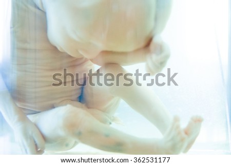 Baby sleeping on a blanket while her mother looks