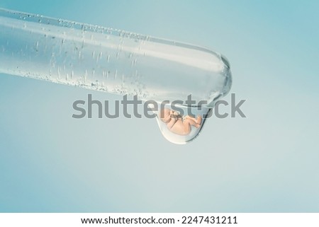 A fetus on a blue background in a drop of liquid. a genetic experiment with the creation of a new life. The concept of cloning.