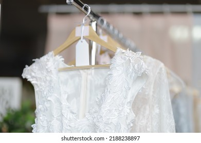 Few beautiful dresses on hanger in wedding salon or atelier sewing studio. Wedding exhibition or shop, evening and bridesmaid dresses. Holiday and events clothes rental. Personal sewing clothes - Shutterstock ID 2188238897