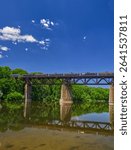 A few clouds roll over the freight trin crossing the Grand river, Paris, ON, Canada