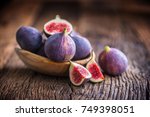 A few figs in a bowl on an old wooden background.