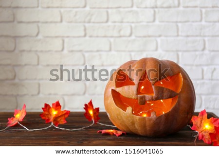 Few orange pumpkins of different size carved into Jack o Lantern on wooden table. Background, copy space, close up, top view. All hallows eve Halloween party decoration. Trick or treat concept.