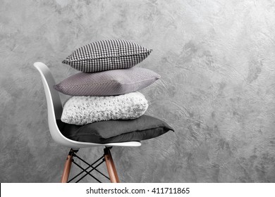 Few pillows on chair against blue wall background
